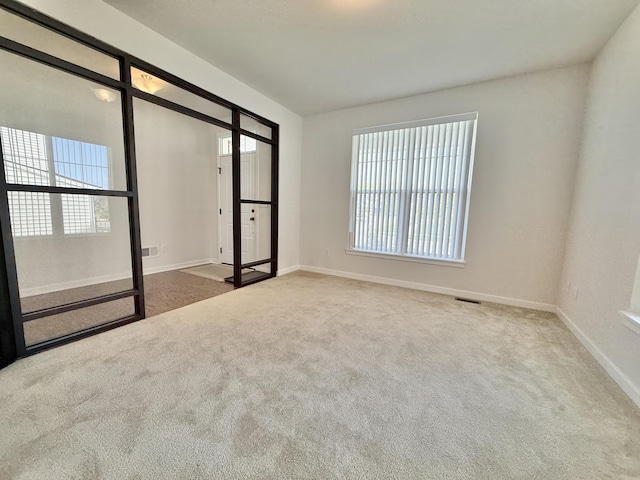 carpeted empty room featuring baseboards