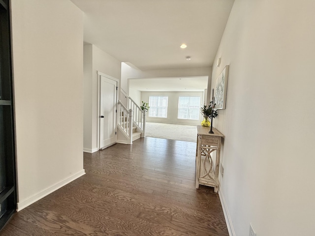 hallway featuring dark wood finished floors, stairway, baseboards, and recessed lighting