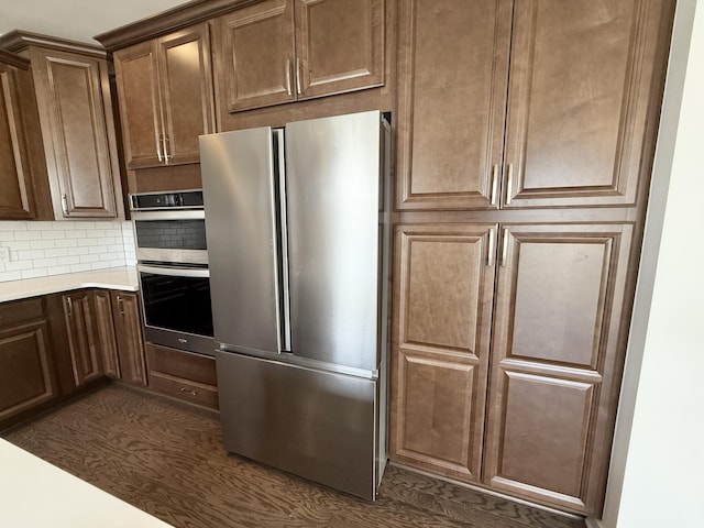 kitchen featuring appliances with stainless steel finishes, decorative backsplash, and light countertops