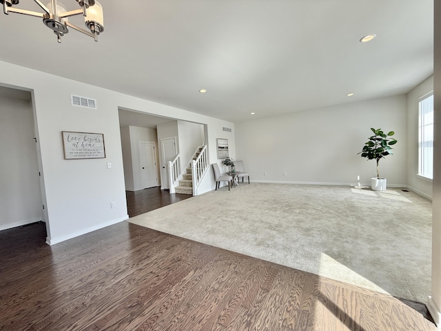 unfurnished living room with stairs, a chandelier, baseboards, dark wood-style flooring, and recessed lighting