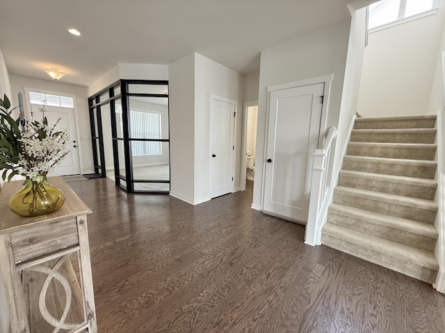 entryway with dark wood-style floors, stairs, baseboards, and recessed lighting