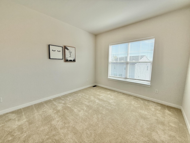 empty room featuring carpet floors and baseboards