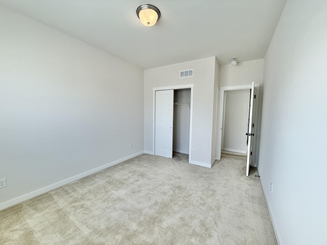 unfurnished bedroom featuring light colored carpet, baseboards, and a closet