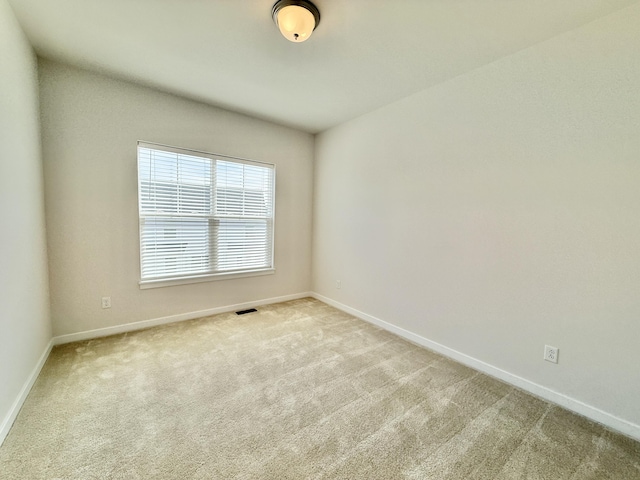 carpeted spare room featuring baseboards