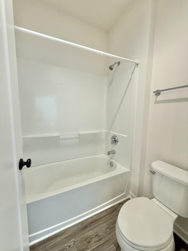 full bath with wood finished floors, toilet, and shower / bathtub combination