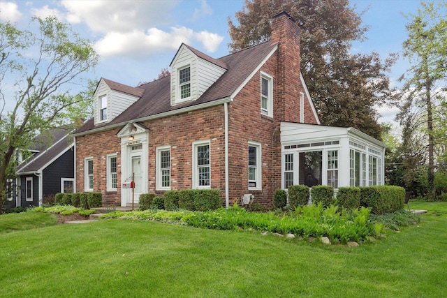 view of home's exterior with a yard, brick siding, and a chimney