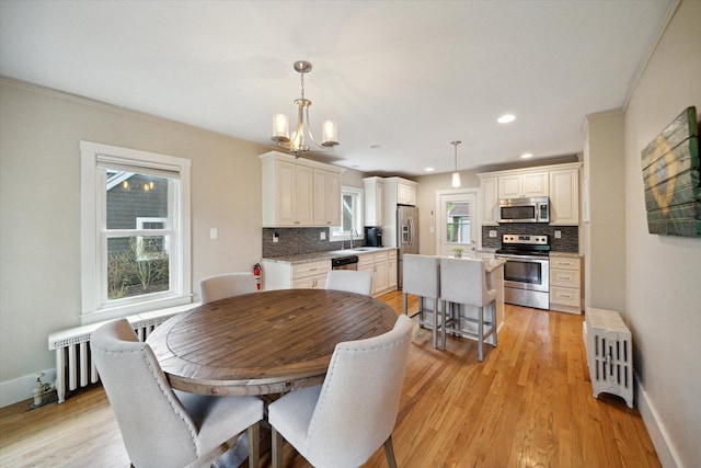 dining area featuring radiator, light wood-type flooring, baseboards, a chandelier, and recessed lighting