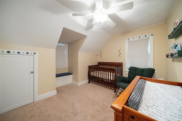 carpeted bedroom featuring vaulted ceiling, ceiling fan, baseboards, and a nursery area