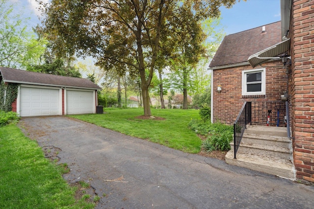 view of green lawn with a garage and an outdoor structure