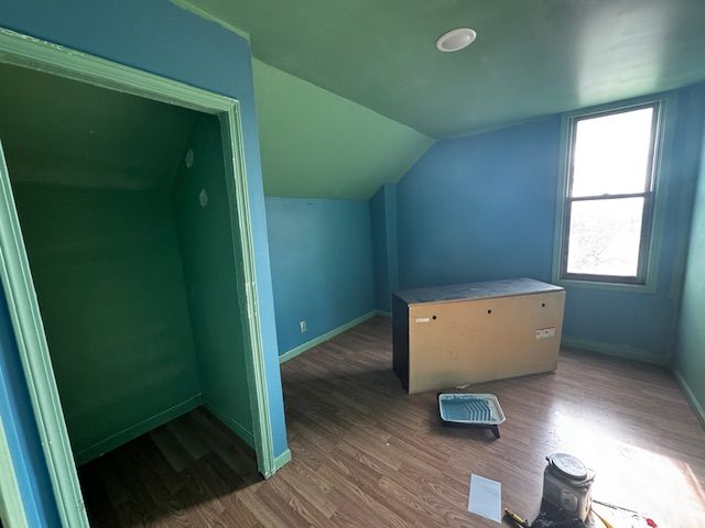 1143 Ballard St, Lansing, MI 48906 - additional living space with wood finished floors, lofted ceiling, and baseboards