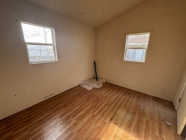 1143 Ballard St, Lansing, MI 48906 - unfurnished room featuring lofted ceiling, light wood-style flooring, and baseboards