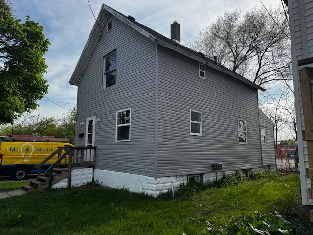 1143 Ballard St, Lansing, MI 48906 - view of side of property with a chimney and a yard