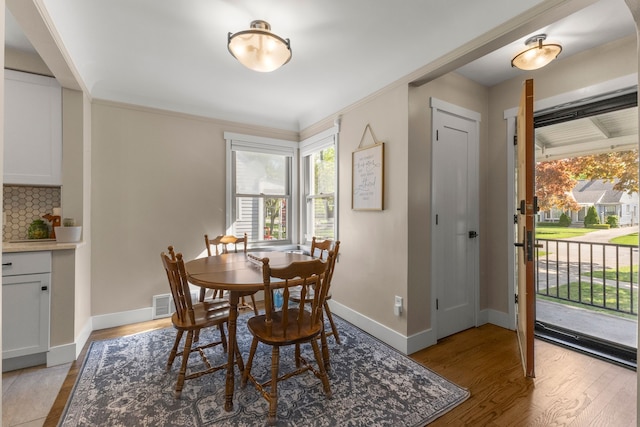 dining area featuring light wood finished floors and baseboards