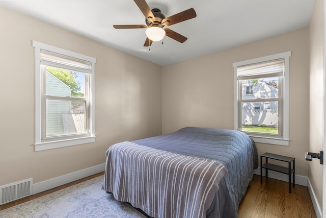 bedroom with wood finished floors, baseboards, and ceiling fan