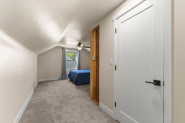 unfurnished bedroom with light carpet, lofted ceiling, baseboards, and ceiling fan