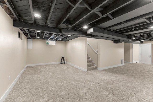 below grade area with carpet floors, stairway, and baseboards