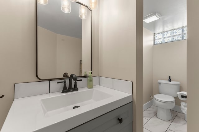 half bathroom with marble finish flooring, toilet, and vanity