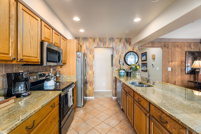 1366 E Coon Lake Rd, Howell, MI 48843 - kitchen featuring appliances with stainless steel finishes, a sink, brown cabinets, light stone counters, and recessed lighting