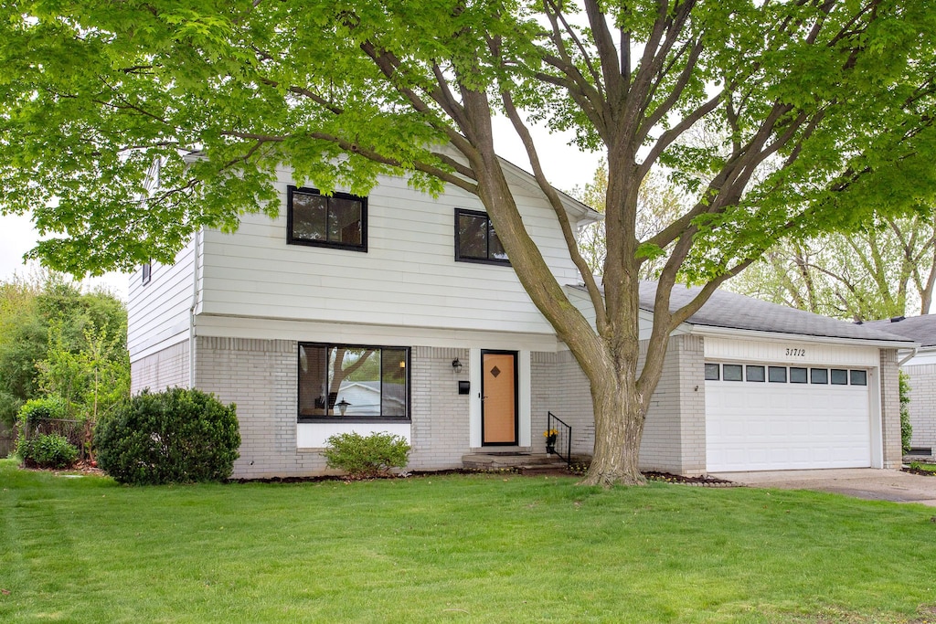 31712 Madison Ave, Madison Heights, MI 48071 - view of front of property featuring brick siding, an attached garage, a front yard, and driveway