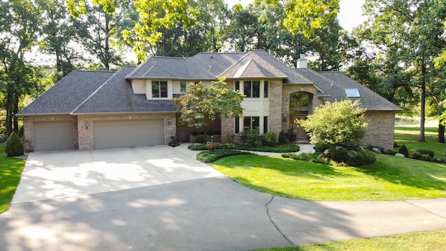 2865 Vw Ave E, Vicksburg, MI 49097 - view of front of home with driveway, a garage, a front lawn, brick siding, and a chimney