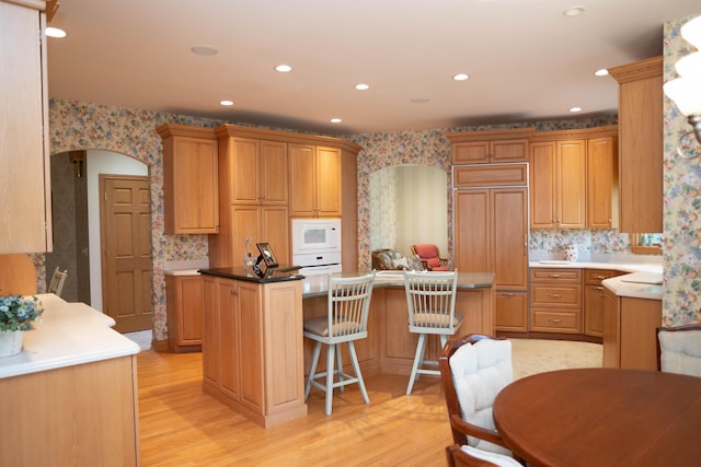 2865 Vw Ave E, Vicksburg, MI 49097 - kitchen featuring white appliances, a center island, a breakfast bar area, light wood-style flooring, and recessed lighting