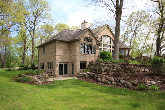 2865 Vw Ave E, Vicksburg, MI 49097 - rear view of property with brick siding, a chimney, a patio area, and a lawn