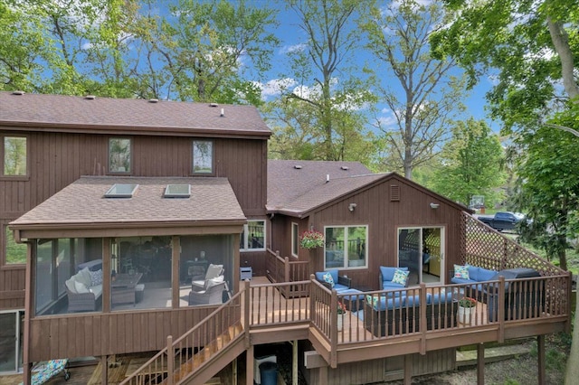 back of house featuring roof with shingles, an outdoor living space, a sunroom, a deck, and stairs