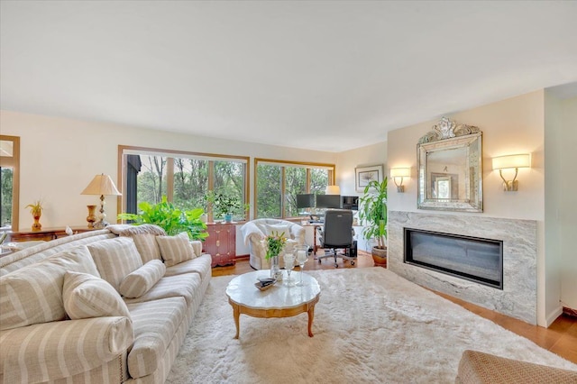 living area with wood finished floors, a high end fireplace, and an office area
