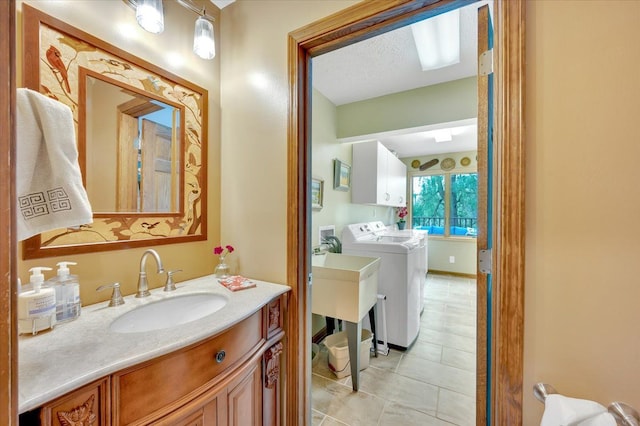 bathroom with a sink, tile patterned flooring, and separate washer and dryer