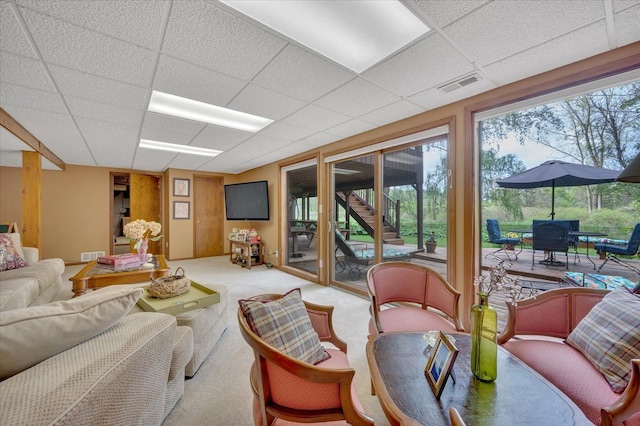 carpeted living room with a drop ceiling