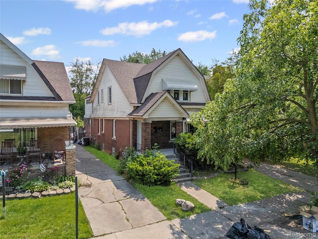 5856 Barrett St, Detroit, MI 48213 - dutch colonial with a porch, brick siding, a gambrel roof, and a front yard