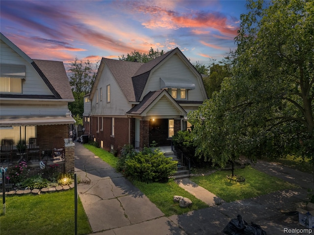 5856 Barrett St, Detroit, MI 48213 - dutch colonial featuring brick siding, a front yard, a gambrel roof, and covered porch
