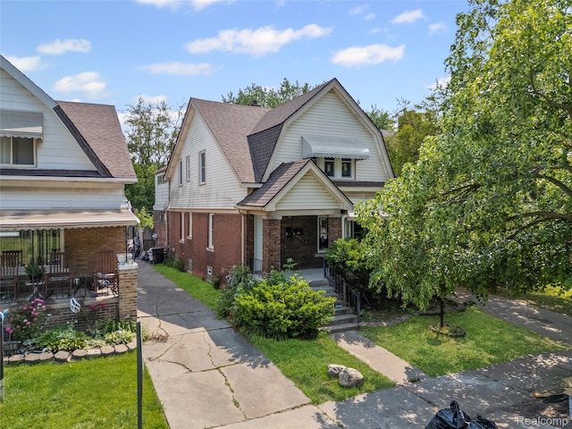 5856 Barrett St, Detroit, MI 48213 - dutch colonial with a porch, brick siding, a front yard, and a gambrel roof