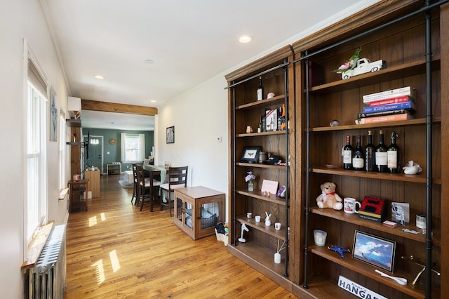 corridor with light wood-style flooring, radiator, recessed lighting, and ornamental molding