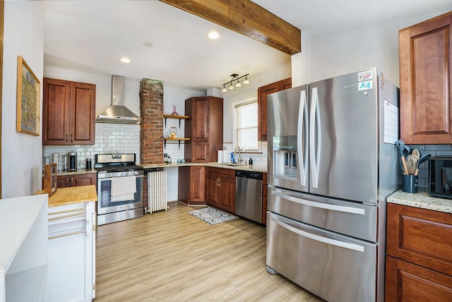 kitchen featuring stainless steel appliances, wall chimney range hood, a sink, open shelves, and tasteful backsplash