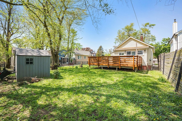 view of yard with a deck, a shed, and an outbuilding