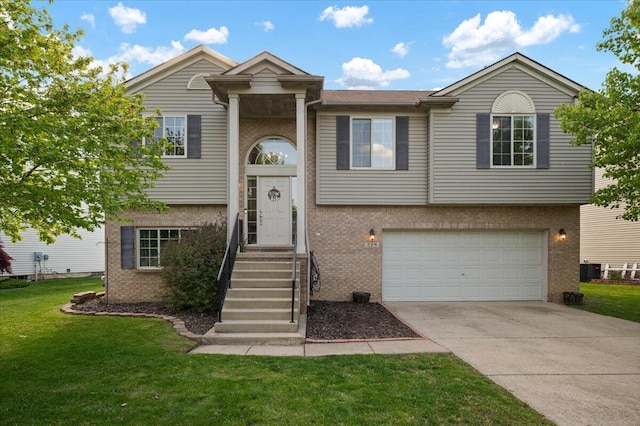 215 Caribou Run, Dundee, MI 48131 - bi-level home with brick siding, a front lawn, a garage, and driveway