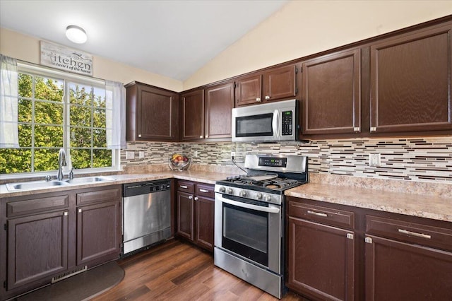 215 Caribou Run, Dundee, MI 48131 - kitchen with stainless steel appliances, a sink, vaulted ceiling, dark brown cabinets, and light countertops