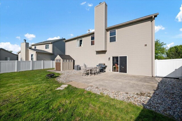 215 Caribou Run, Dundee, MI 48131 - rear view of house featuring a shed, an outdoor structure, a patio, a chimney, and an outdoor fire pit