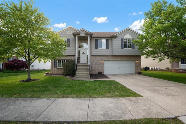 215 Caribou Run, Dundee, MI 48131 - split foyer home with an attached garage, a front yard, concrete driveway, and brick siding