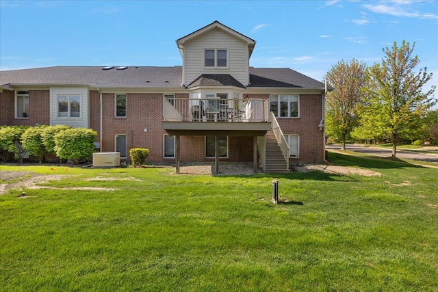 rear view of house featuring stairway, a wooden deck, a yard, and brick siding
