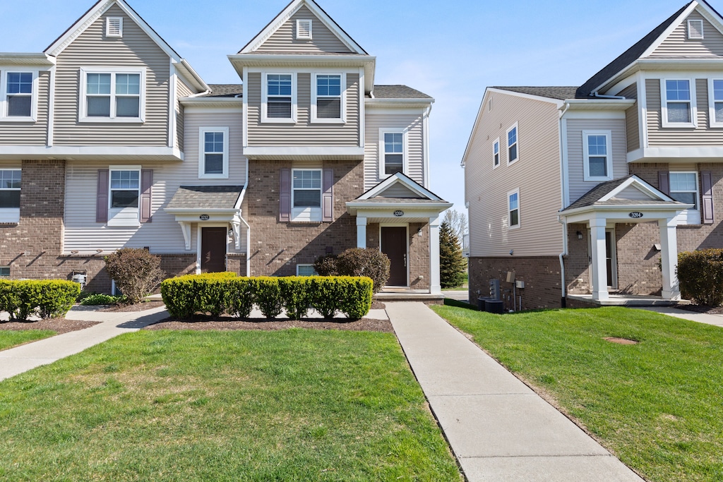 3208 Johanna Ware W, Wixom, MI 48393 - townhome / multi-family property featuring brick siding and a front lawn