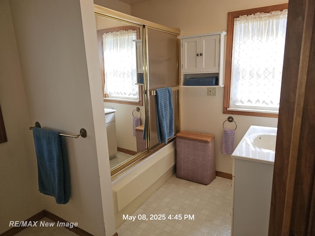 1551 Division St, Saginaw, MI 48602 - full bath with tile patterned floors, baseboards, vanity, and enclosed tub / shower combo