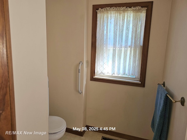 1551 Division St, Saginaw, MI 48602 - bathroom featuring plenty of natural light, toilet, and baseboards
