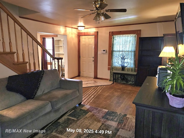 1551 Division St, Saginaw, MI 48602 - living room with stairs, plenty of natural light, a ceiling fan, and wood finished floors