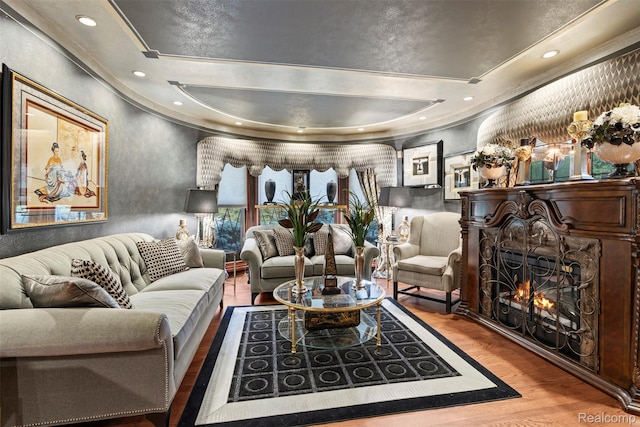 7310 Sandy Creek Ln, Bloomfield Hills, MI 48301 - living room with wood finished floors, a lit fireplace, a tray ceiling, a textured wall, and ornamental molding