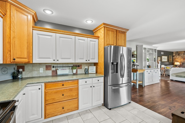 15974 Rustic Ln S, Vicksburg, MI 49097 - kitchen with appliances with stainless steel finishes, decorative backsplash, open floor plan, light tile patterned floors, and white cabinetry