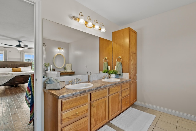 15974 Rustic Ln S, Vicksburg, MI 49097 - bathroom featuring a ceiling fan, double vanity, baseboards, and tile patterned floors