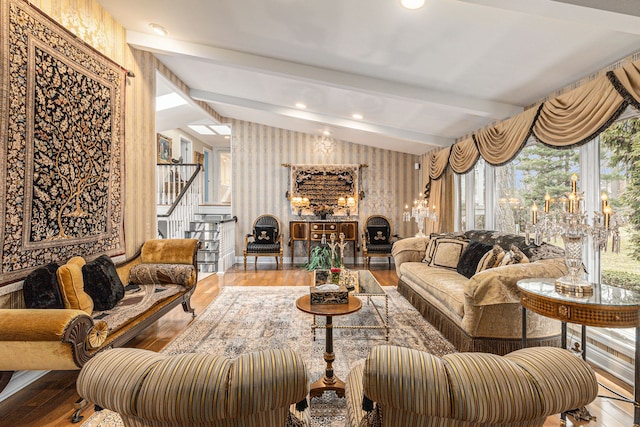 living room featuring wallpapered walls, hardwood / wood-style floors, stairway, beam ceiling, and plenty of natural light