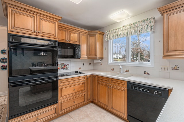 kitchen featuring black appliances, a sink, backsplash, and brown cabinets